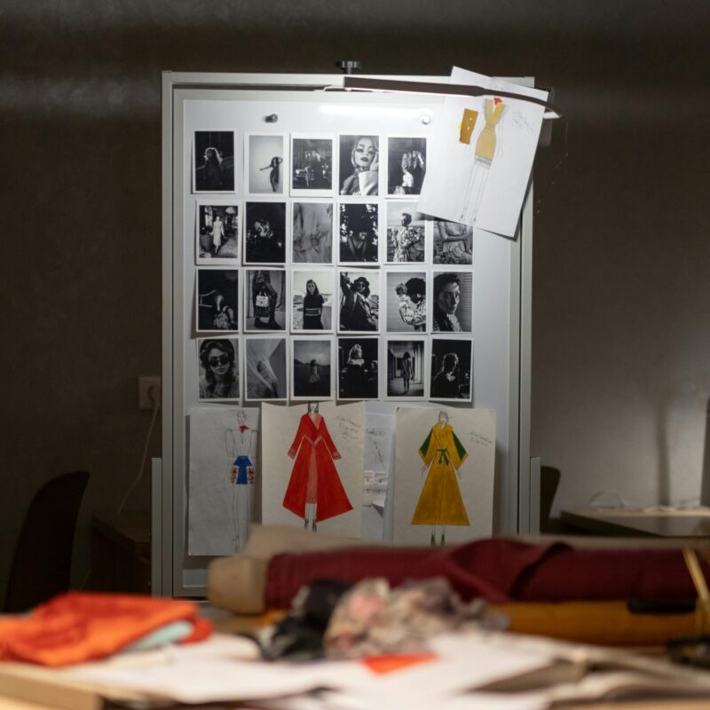 Creative fashion design workspace with sketches and photos, ideal for artistic inspiration.